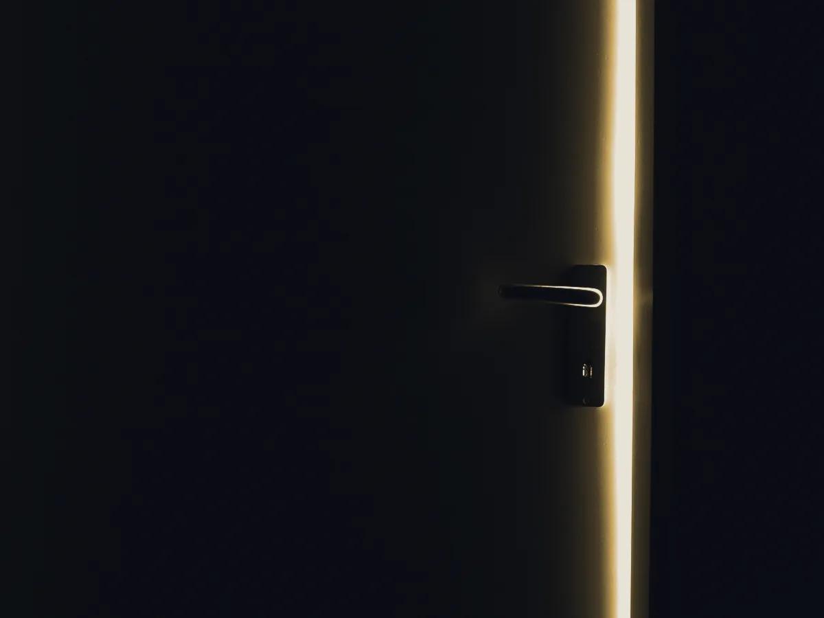A single quiet lamp in a dark room